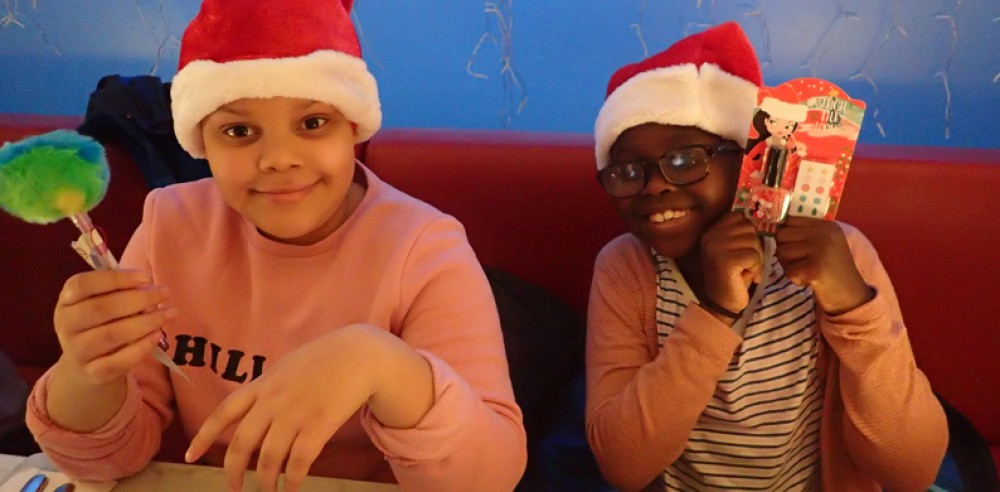 Two children holding Christmas presents