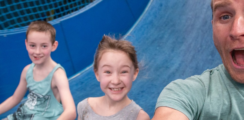 Volunteer with children going down a slide